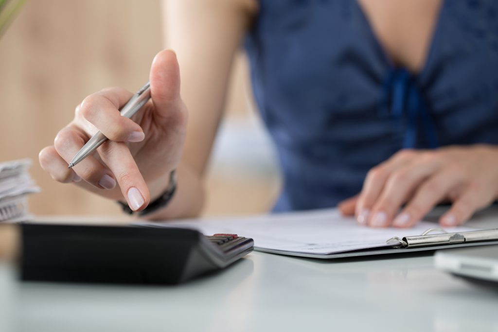 Close up of female making calculations, ERP(Enterprise Resource Planning) System in Singapore